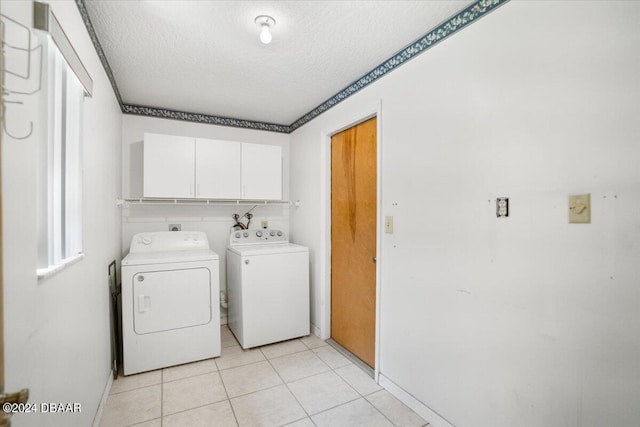 washroom featuring separate washer and dryer, cabinets, a textured ceiling, and light tile patterned flooring