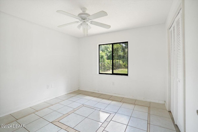 unfurnished bedroom featuring light tile patterned floors, a closet, and ceiling fan