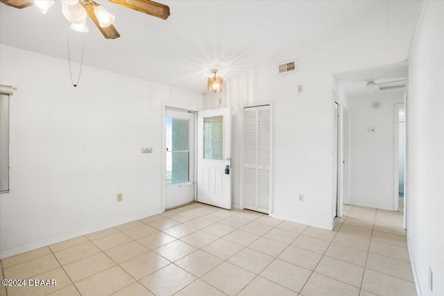 tiled empty room featuring ceiling fan