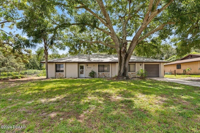 single story home featuring a garage and a front yard