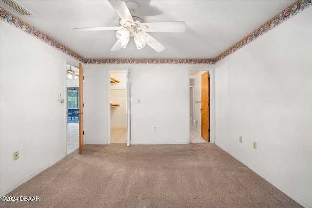 carpeted spare room with a textured ceiling and ceiling fan