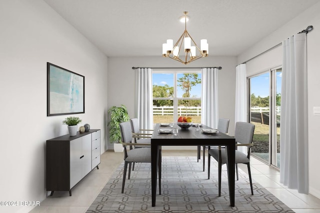 dining area with a healthy amount of sunlight, light tile patterned floors, and an inviting chandelier