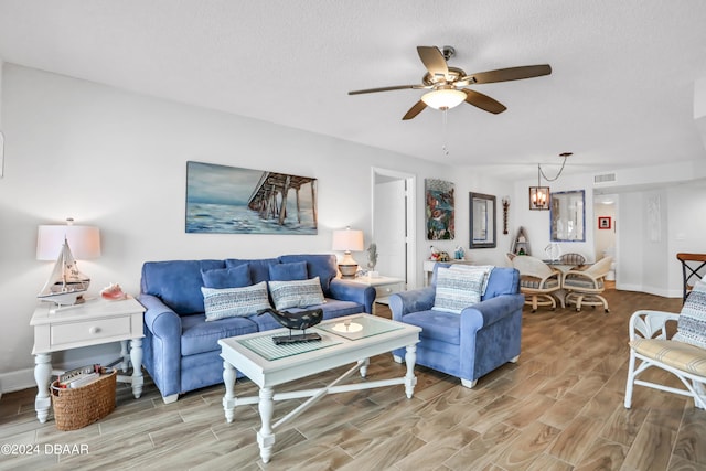 living room featuring a textured ceiling, hardwood / wood-style flooring, and ceiling fan with notable chandelier