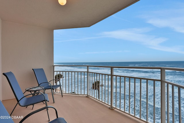 balcony featuring a water view and a view of the beach