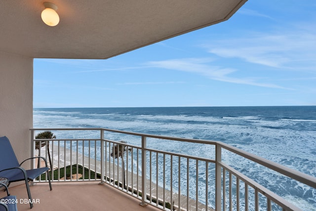 balcony with a water view and a beach view