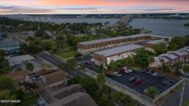 aerial view at dusk featuring a water view