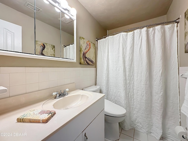 bathroom featuring tile patterned flooring, toilet, visible vents, vanity, and tile walls