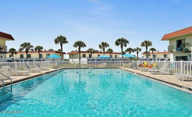 pool with a patio area and fence