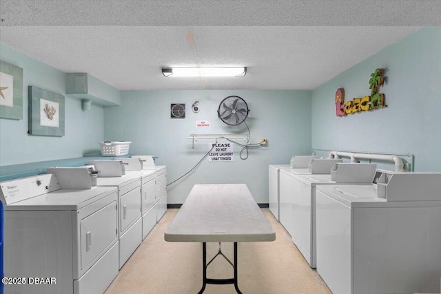 shared laundry area featuring washing machine and clothes dryer and a textured ceiling