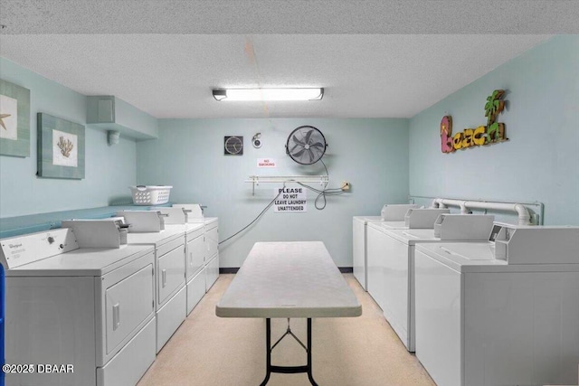 washroom with washing machine and clothes dryer and a textured ceiling