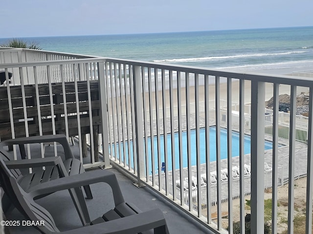 balcony with a water view and a beach view