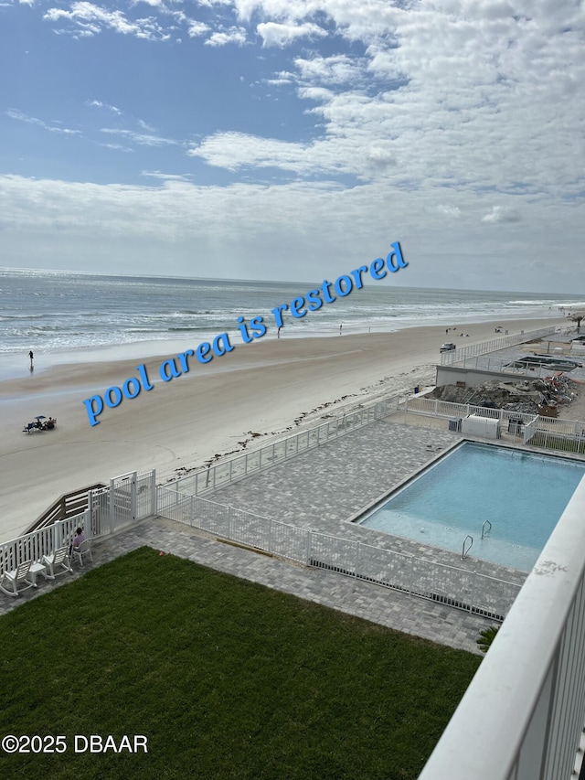 view of water feature featuring fence and a beach view