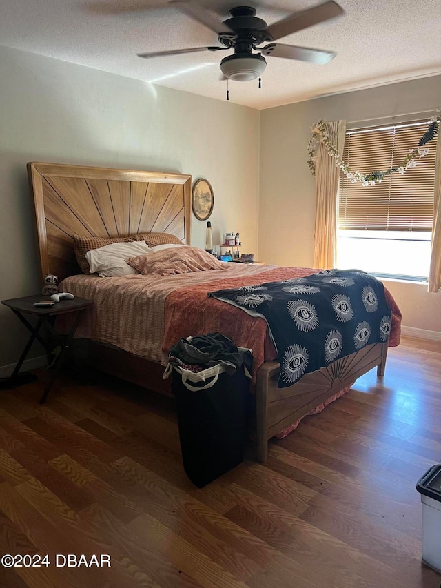 bedroom featuring wood-type flooring, ceiling fan, and a textured ceiling