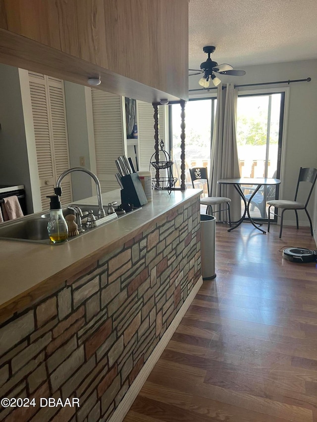 kitchen with a textured ceiling, dark hardwood / wood-style floors, sink, and ceiling fan