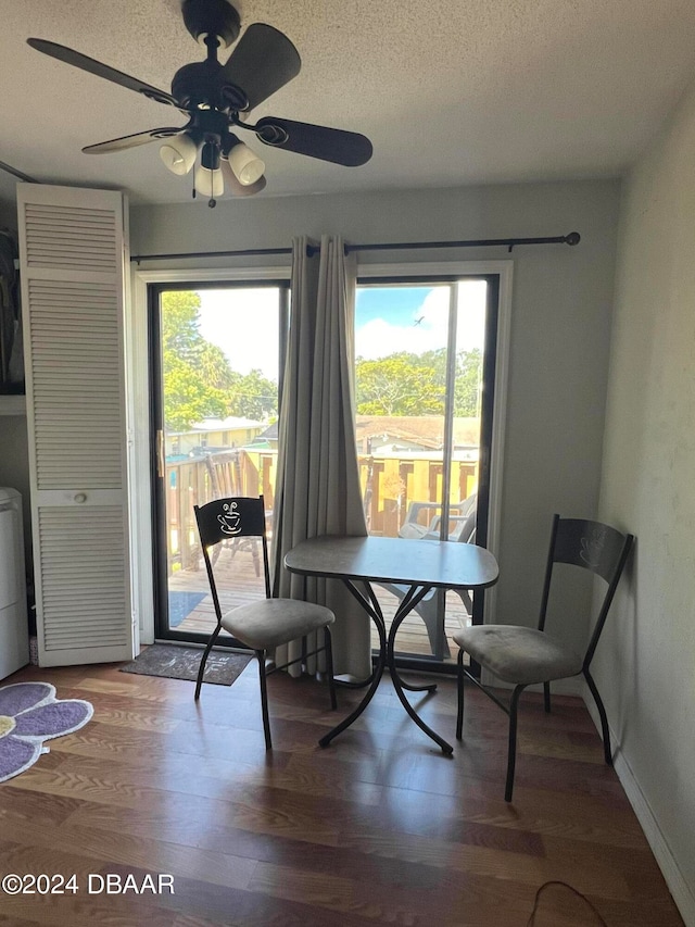 dining space featuring stacked washing maching and dryer, hardwood / wood-style floors, a textured ceiling, and ceiling fan