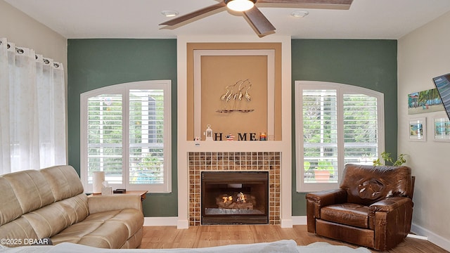 living area with wood finished floors, a ceiling fan, and healthy amount of natural light