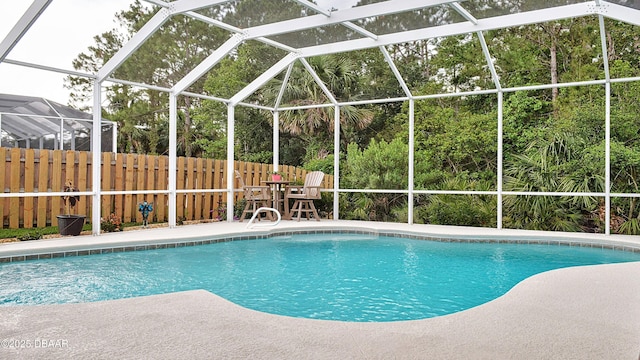 view of swimming pool featuring fence, a patio area, and glass enclosure