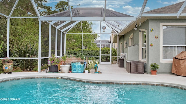 swimming pool with a patio area and glass enclosure
