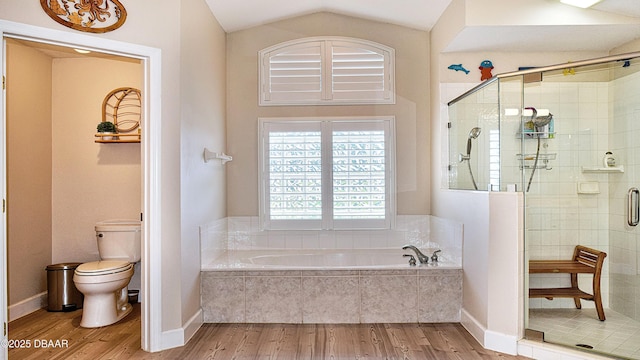 full bath featuring wood finished floors, a stall shower, a garden tub, toilet, and lofted ceiling