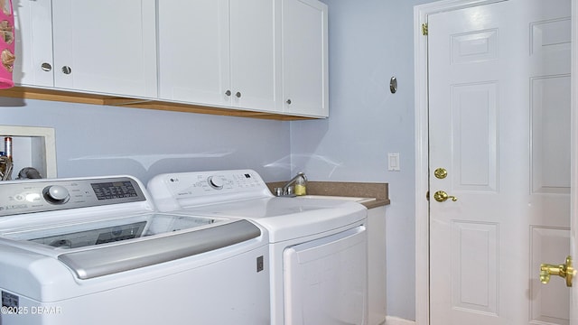 washroom featuring washing machine and clothes dryer and cabinet space