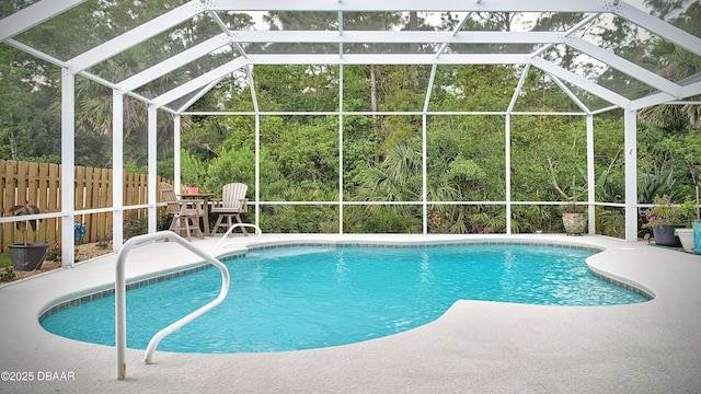 view of swimming pool featuring a patio, fence, and a lanai