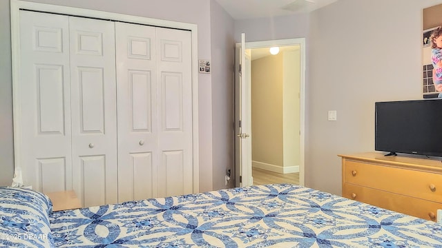 bedroom featuring a closet, wood finished floors, and baseboards