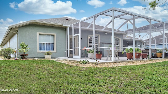 rear view of house with a patio, a lanai, stucco siding, and a yard