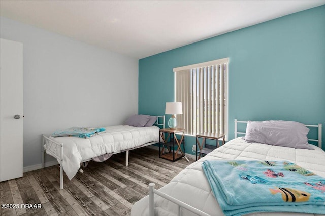 bedroom with wood finished floors and multiple windows