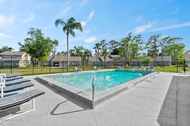 community pool with fence, a residential view, a yard, and a patio area