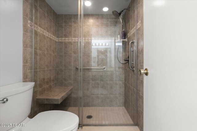 bathroom featuring toilet and a stall shower