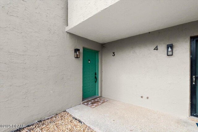 property entrance with stucco siding