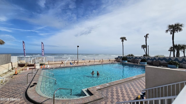 view of pool featuring a water view and a patio