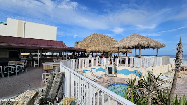 view of pool with a gazebo, a water view, an outdoor bar, and central AC unit