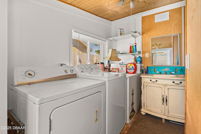 washroom featuring visible vents, washer and clothes dryer, wood ceiling, laundry area, and a sink