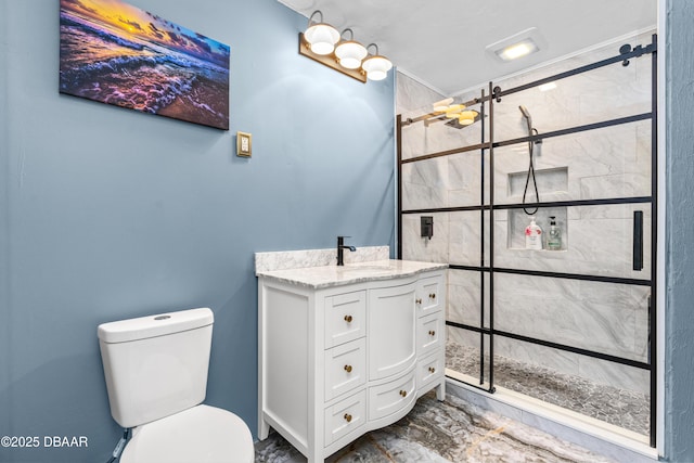 bathroom featuring toilet, marble finish floor, a stall shower, and vanity