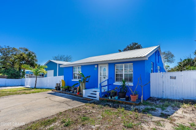 view of front of house with metal roof and fence