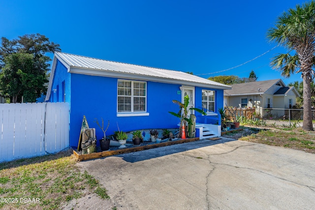 view of front of property with fence and metal roof