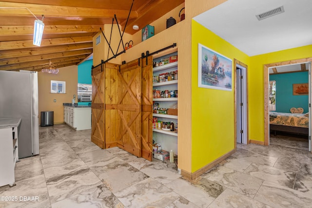 hall featuring baseboards, visible vents, vaulted ceiling, a barn door, and marble finish floor