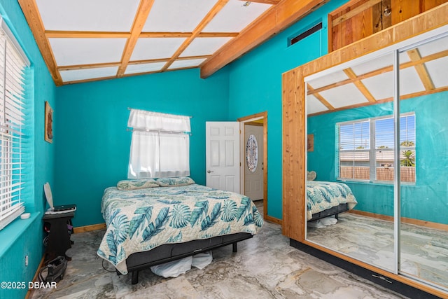 bedroom with vaulted ceiling with beams and baseboards