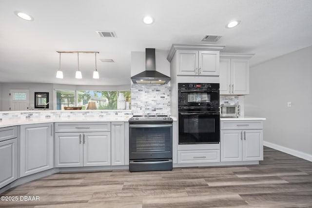 49 Bosarvey Cir, Ormond Beach, FL 32176 - kitchen with stainless steel electric stove, wall chimney range hood, backsplash, light countertops, and light wood-style floors