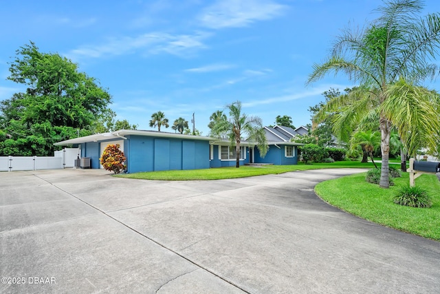 49 Bosarvey Cir, Ormond Beach, FL 32176 - ranch-style house with curved driveway, a gate, board and batten siding, and an attached garage