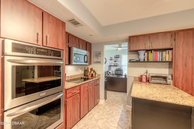 kitchen featuring light tile patterned flooring, appliances with stainless steel finishes, light stone countertops, decorative backsplash, and ceiling fan