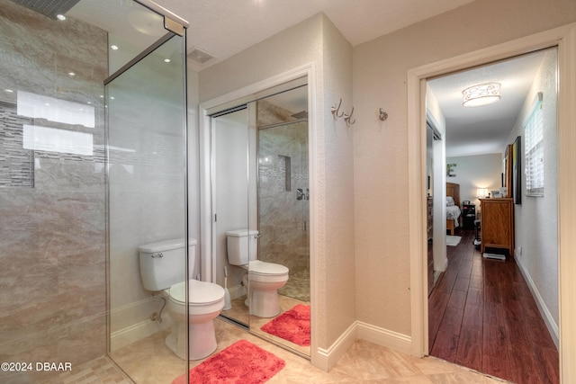 bathroom featuring walk in shower, wood-type flooring, a textured ceiling, and toilet