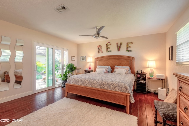 bedroom with dark wood-type flooring, multiple windows, and access to exterior