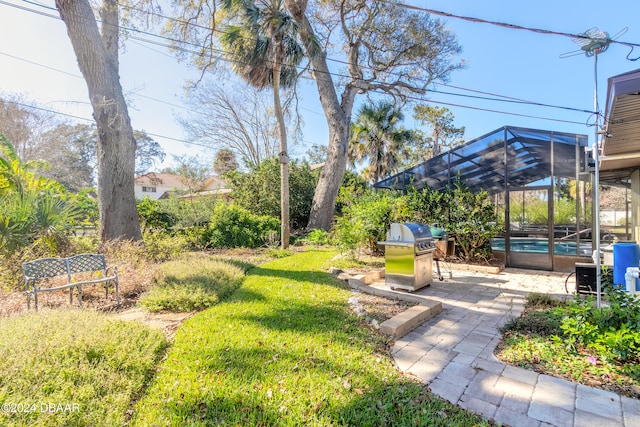 view of yard featuring glass enclosure, a patio area, and a pool