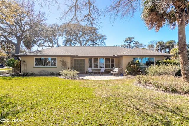 back of house with a lawn and a patio