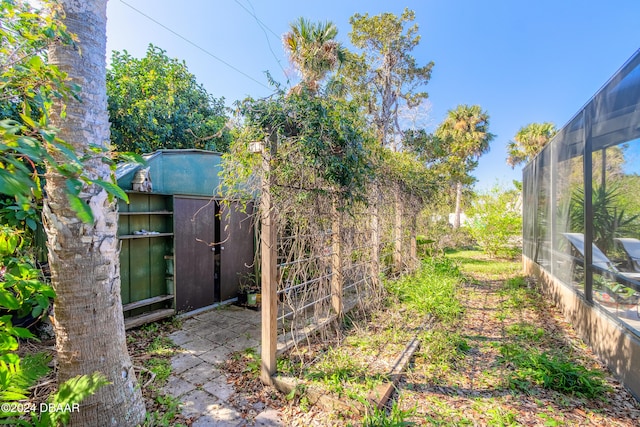 view of yard featuring glass enclosure and an outdoor structure