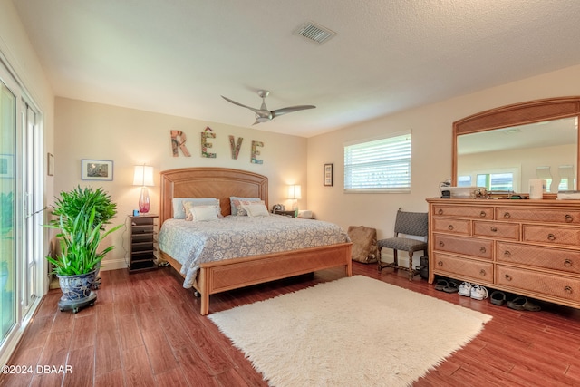 bedroom featuring dark wood-type flooring, access to outside, and ceiling fan