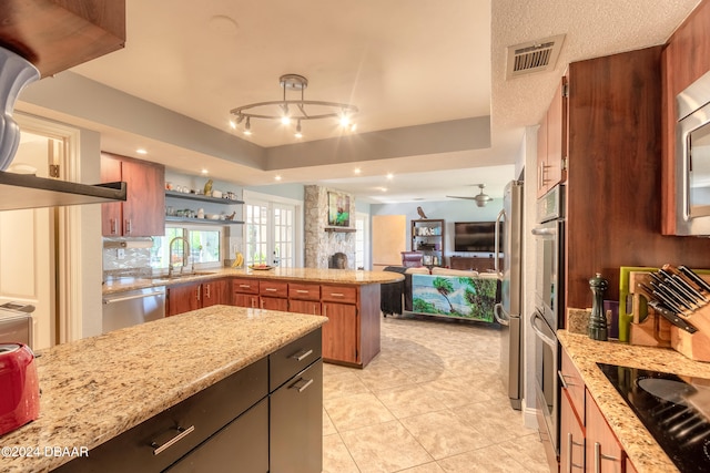 kitchen featuring light tile patterned floors, sink, ceiling fan, light stone countertops, and appliances with stainless steel finishes