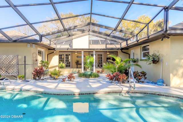 view of pool featuring glass enclosure, a patio, and ceiling fan